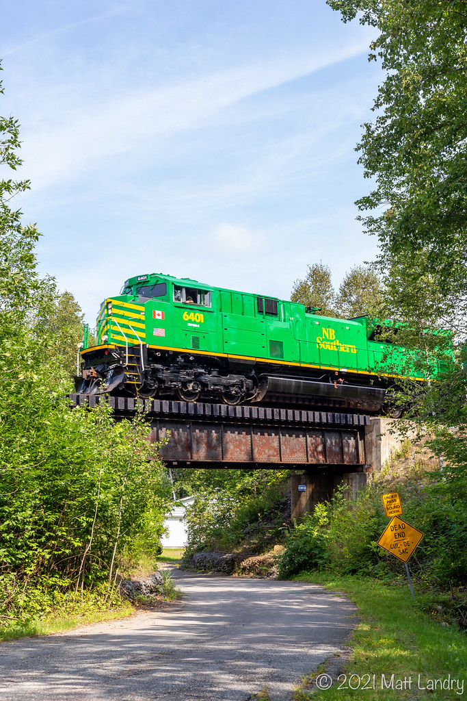 NBSR 6401 powers train 907 as they head over a small trestle approaching Westfield Beach, New Brunswick.