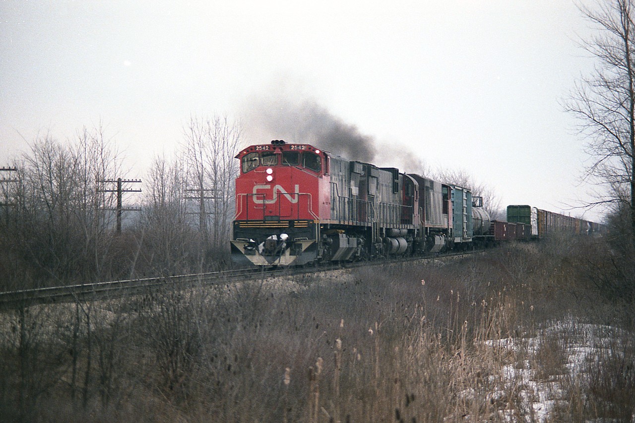 Just another CN powered train, but this is more like a 'blast from the past'.   CN 2542  (M-420(W) was renumbered to 3542 in 1987, later sold to Hudsons Bay Rwy;  2006   C-630M (retired 1992) and  2117  (BBD H616 retired 1997, sold to NRE)make up the power for this train. This scene was captured from Pettit Rd in Fort Erie as the train accelerated away from CN Duff at west end of the yard.
The BBD locomotive only last 15 years, having been built in 1982.