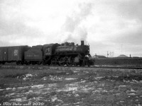 Not the best quality photo, as this was scanned from a somewhat grainy 35mm B&W film exposure, but here's CPR D10g 896 (a CLC-built 4-6-0, built March 1911, scrapped by CPR Angus in October 1957) near the end of its career, heading up a short local freight on the Scarborough Industrial Spur during March of 1956. The train has just come off CP's Belleville Sub at Mile 201.36 (note the mainline running in the background on the embankment) and is about to cross Warden Avenue at-grade. The houses in the background are off Dalecliff Crescent, built only a few years earlier during the post-war suburban Scarborough boom. Much of the area was still undergoing transition from rural/agricultural to suburban and industrial (see the <a href=http://jpeg2000.eloquent-systems.com/toronto.html?image=ser12/s0012_fl1957_it0071.jp2><b>1957 aerial</b></a> here), and the line ran along some empty stretches where industrial warehouses and factories would later be built (some with private sidings for rail service). Customers around Warden Avenue serviced by rail at the time appear to be two lumber yards, and a construction aggregate site.<br><br> (Most of the history of the Scarborough Industrial Spur was previously detailed in <a href=http://www.railpictures.ca/?attachment_id=45682><b>this photo of CP RS3 8445</b></a>).<br><br><i>Original photographer unknown, Dan Dell'Unto collection negative (with some restoration work).</i>