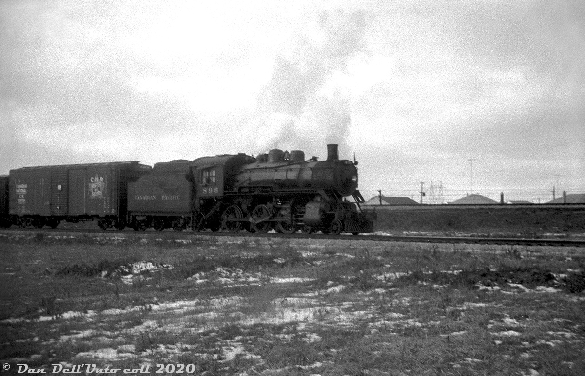 Not the best quality photo, as this was scanned from a somewhat grainy 35mm B&W film exposure, but here's CPR D10g 896 (a CLC-built 4-6-0, built March 1911, scrapped by CPR Angus in October 1957) near the end of its career, heading up a short local freight on the Scarborough Industrial Spur during March of 1956. The train has just come off CP's Belleville Sub at Mile 201.36 (note the mainline running in the background on the embankment) and is about to cross Warden Avenue at-grade. The houses in the background are off Dalecliff Crescent, built only a few years earlier during the post-war suburban Scarborough boom. Much of the area was still undergoing transition from rural/agricultural to suburban and industrial (see the 1957 aerial here), and the line ran along some empty stretches where industrial warehouses and factories would later be built (some with private sidings for rail service). Customers around Warden Avenue serviced by rail at the time appear to be two lumber yards, and a construction aggregate site. (Most of the history of the Scarborough Industrial Spur was previously detailed in this photo of CP RS3 8445).Original photographer unknown, Dan Dell'Unto collection negative (with some restoration work).