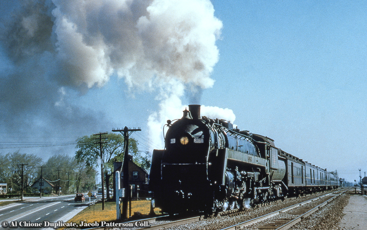 At about 0846h CNR U-1-f 6068 is seen accelerating away from the flag stop of Burlington on the point of train 101.  Running from Toronto (Dep. 0800h) to Hamilton James Street station (Arr. 0900h), the train will continue on from Hamilton (Dep. 0915h) to Niagara Falls (Arr. 1050h) as train 102, having gone from a westbound to an eastbound train at Hamilton.*  Built in November 1944, 6068 would be scrapped in October 1961.  Note the crossing watchman's tower in the distance at Brant Street.More Burlington (West):Westbound CN passenger, note watch tower, Dave Burroughs, 1967.Westbound CP intermodal, Steve Host, 2004.Burlington (Jct.) station now preserved, Arnold Mooney, 2018.An article on Burlington station by the TRHA can be found here.*Information per 1957 CNR London Division Employee Timetable, many thanks goes to Charles Cooper for his extensive collection which has helped in identifying operations in many of these slides.Original Photographer Unknown, Al Chione Duplicate, Jacob Patterson Collection