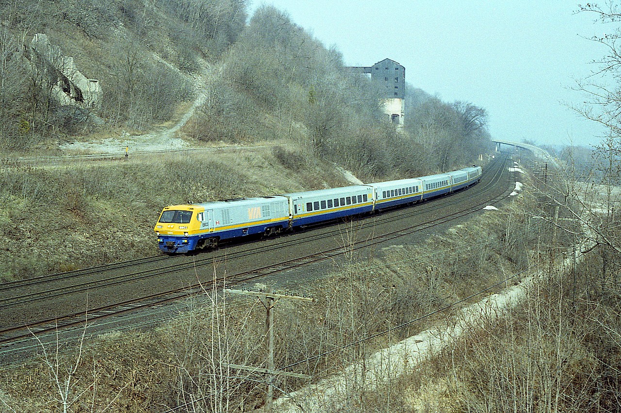 Sitting up on my favourite perch at Dundas, overlooking the remnants of the Canada Crushed Stone facility (closed 1974) I actually was treated to sunshine. VIA 6903 (with 6918 trailing)is looking good running westbound. Unfortunately, looks can be deceiving.  The LRC-2 (6900-6920) and -3 series (6921-6930) from Bombardier proved to be a form of rolling lemons, and they did not last all that long from their building dates of 1982/83. This particular unit (6903) was sold to Diesel Electric in 2006 after being on the shelf for quite some time. The 6918 trailing was sold to CAD Rail Services in 2002.
The line in the lower right led to the Steetley Dolomite business and was pulled up in 1985.