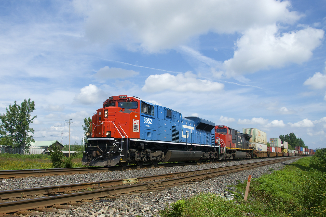 The Grand Trunk heritage unit is leading a late CN 185 as it approaches a crossing at MP 35.74 of the Kingston Sub with CN 8952, IC 2719 and a 448-axle long train.