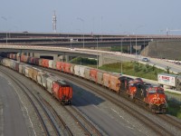 In a rare configuration for this train, potash train CN B730 has a pair of DPU's (CN 3216 & CN 3859) shoving on the rear end as the train passes a cut of parked grain cars. 