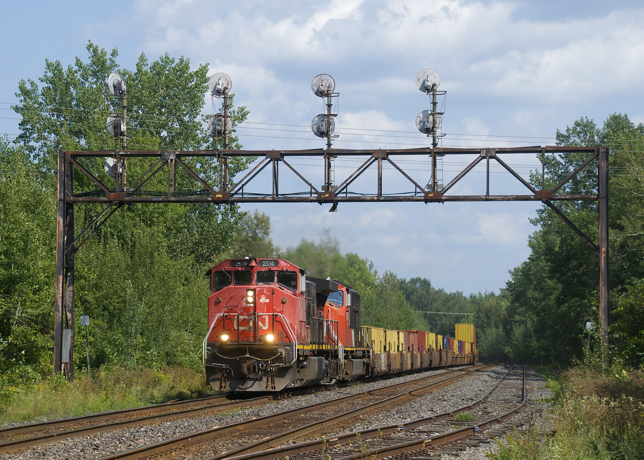 After having to get recrewed before even leaving the Port of Montreal, CN X105 is on its second crew as it passes a classic signal bridge with CN 2514 & CN 5668 for power.