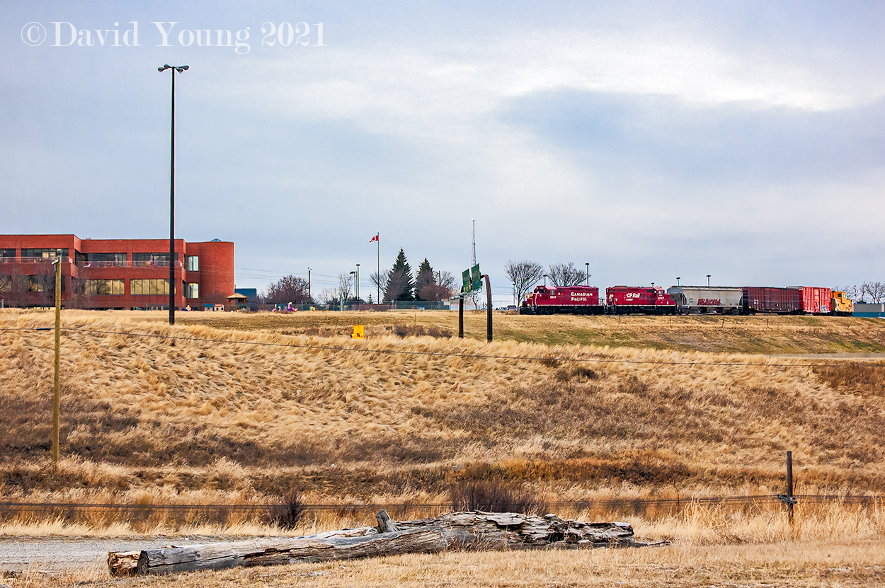 High above the Deerfoot Trail, a CP local with GP9u's 1647 and 1567 complete with an old van, is beginning their descent to the mainline past the Calgary Herald, having completed their days task along the industrial trackage which branches off the Red Deer Sub at Zoo. It's seems its quite the dip down to the mainline... That's the top of the codeline in the foreground!  On a side note, I found my self checking out recent satellite and street view images of the area and this trackage seems to be unused and abandoned. Time marches on...
