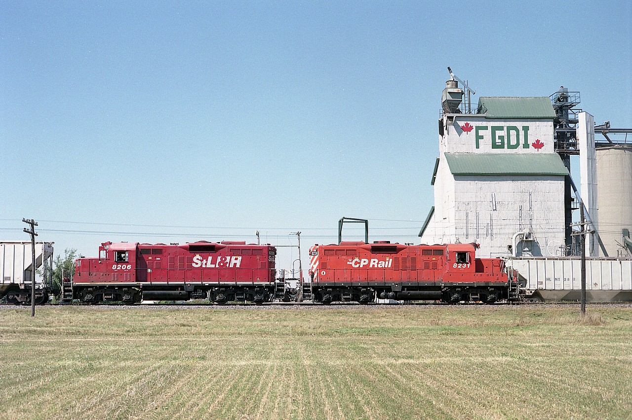 I had previously referred to this location as "Louisville". Well, they are both hamlets and separated by a railroad, a highway, and cornfield.
This image is in conjunction with Todd Steinman's delightful shot of the old FGDI grain mill (#46324) and this shows my view of it across the field. Luckily, the land had just been cleared.
I was rather distraught to hear of the demise of this structure. It made for a great prop, and the likes of these are disappearing all over the country.
On this day, CP 8231 and STLH 8206 are returning eastbound to London from Chatham. On the wayfreight's westbound run to Chatham, I shot from up in the building structure over the hopper car at right. With permission, of course.