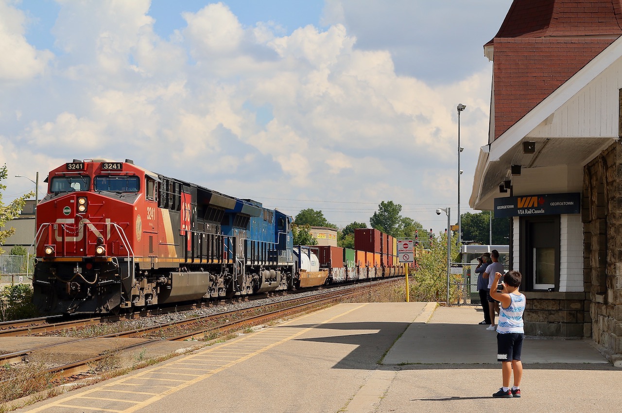 With word that 149 had a former CITI Rail in the lead east of Toronto, and I was already out with the boys for the morning, one way or another we were going to photograph it somewhere. Unfortunately I either was a day late or the power got swapped, LOL. Nevertheless this was a decent consolation prize as the blue GECX units are becoming very hard to find as most have been rebuilt. Here train 149 storms west past old and young railfans, giving a decent horn show possibly thanks to Christians hand signals :) The train is passing the old VIA/GO station at Georgetown as the cloud cover thickens on a very humid late summer day.