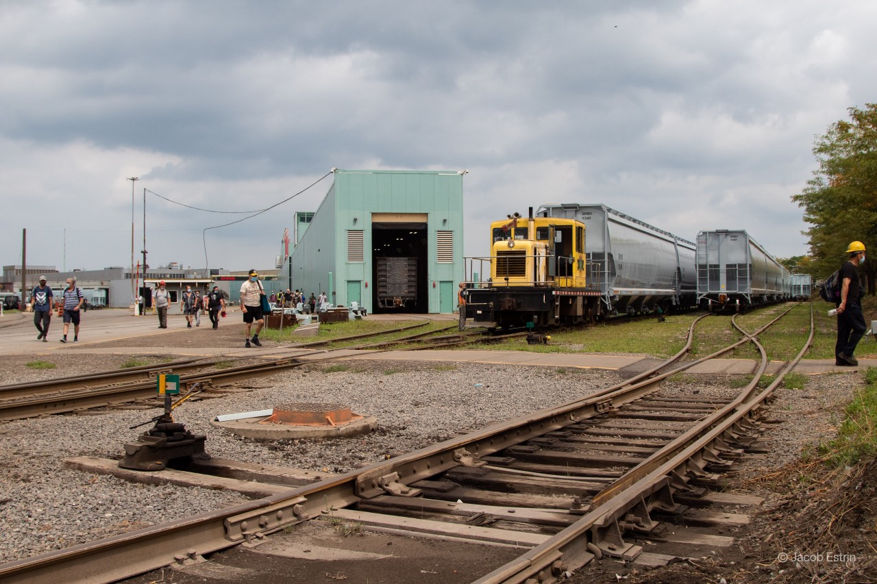 Hundred's and hundred's of employee seen walking out of National Steel Car in Hamilton, Ontario after a long week! I was talking to the crew on the small switcher and they said they normally have to stop and wait for about 30 to 40 minutes every day to let all of the employee's and traffic leave the industry before they can safely continue with they're switching.