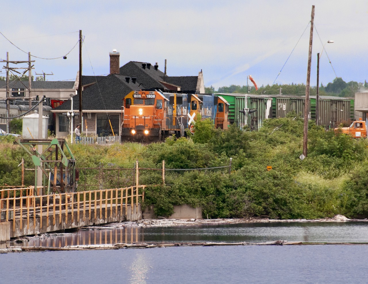 Hearst turn sits in front of the station ready to depart for Hearst after exchanging trains with the turn from Cochrane. The dam on the Kapuskasing River supplies water for the Spruce Falls Paper Co. the towns major industry. This was part of the National Transcontinental  Quebec Winnipeg main, later CN