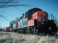 During the afternoon, GP9RM’s 4115 and 4140 with their rail salvage train have finally arrived in the town of Harriston and are seen awaiting instructions from the CN foremen accompanying the crew. The tail-end of the train was at the Raglan Street crossing as the town's old water tower can be seen to the left above the rail cars. 
