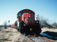 Pictured is a little better view showing the town of Harriston in the background with the rail salvage train. 
<br>
During the afternoon, GP9RM’s 4115 and 4140 with their rail salvage train have finally arrived in the town of Harriston and are seen awaiting instructions from the CN foremen accompanying the crew. The tail-end of the train was at the Raglan Street crossing as the town's old water tower can be seen to the left above the rail cars.
