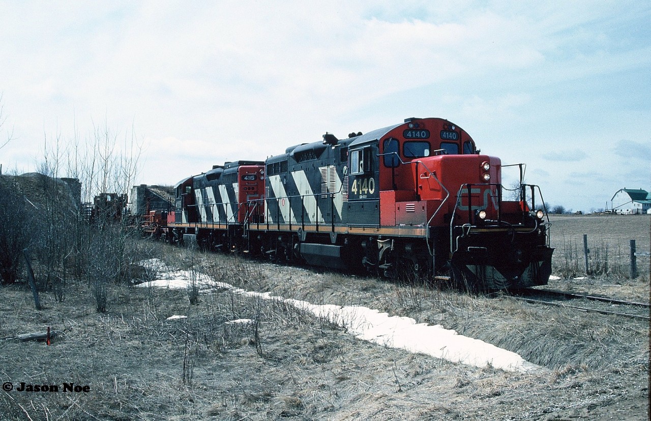 To imagine photographing a place where two historic Ontario branchlines once crossed paths, the over-under at Milverton would be at the top of the list. Situated 27 kilometres North of Stratford on the CN Newton Subdivision at mile 14.4, the community of Milverton once saw CP’s Goderich Subdivision cross over the CN line on an overpass in the middle of adjoining agricultural fields. Previously seeing its last run during December 1988, the CP bridge had since been removed as CN 4140 and 4115 slowly pass through town hauling an empty rail train towards Palmerston on the Newton Subdivision with the final destination of the town of Harriston.