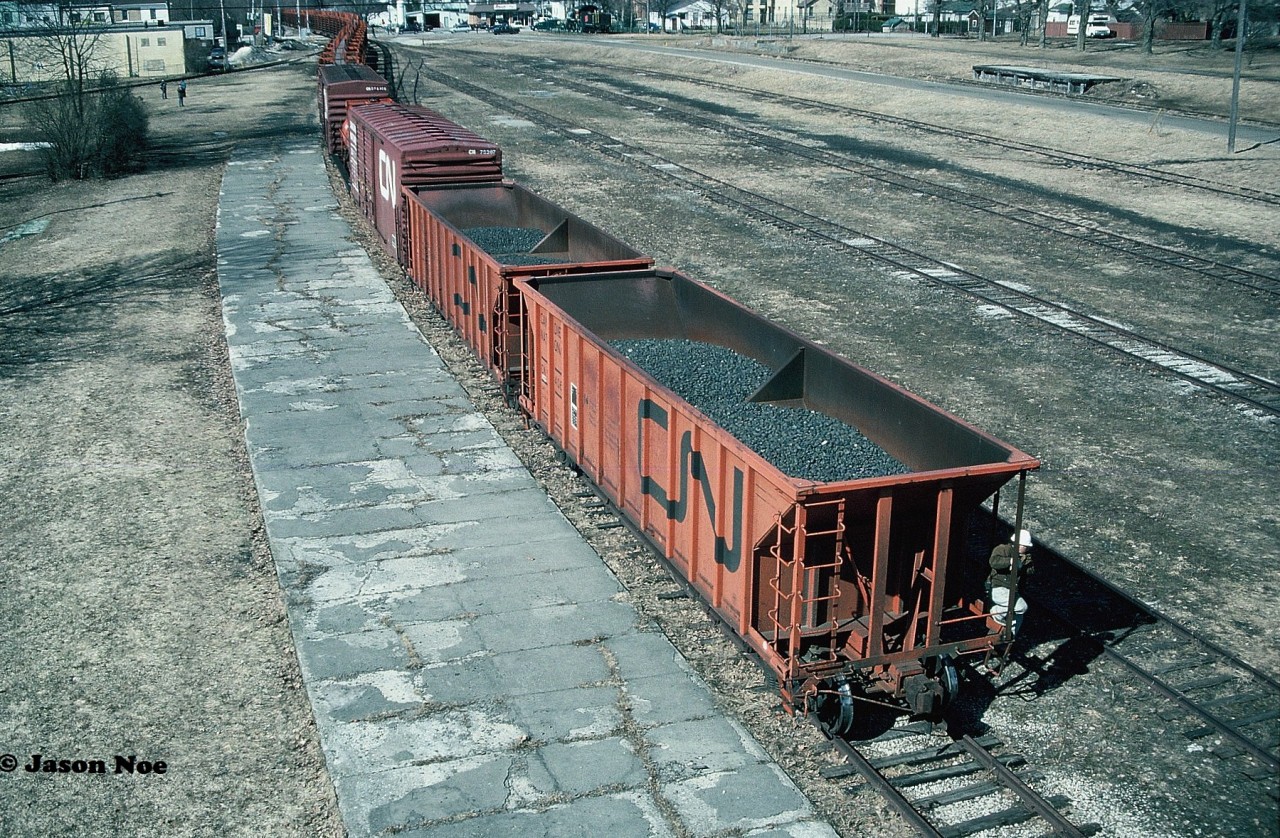 After arriving in the town of Palmerston on the north leg of the old wye, CN GP9RM’s 4140 and 4115 would shove the rail train into the empty yard and by the CN Palmerston station, which at the time was virtually sitting abandoned as well. From there, the units would uncouple from the front, run-around their train in the yard and then couple to the opposite end to await the final leg of their trip to Harriston. From Palmerston, they would shove the remaining five miles into Harriston on the Owen Sound Subdivision. Seen from the town's historic Pedestrian Bridge that spanned the entire yard, the final train it will ever see is about to roll in front of the Palmerston station as several local people came out to take in the event as well.