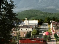 The westbound Shuswap Subdivision wayfreight to Kamloops pulls out of the yard at Revelstoke and crosses MacKenzie Avenue. Mount Begbie oversees the scene