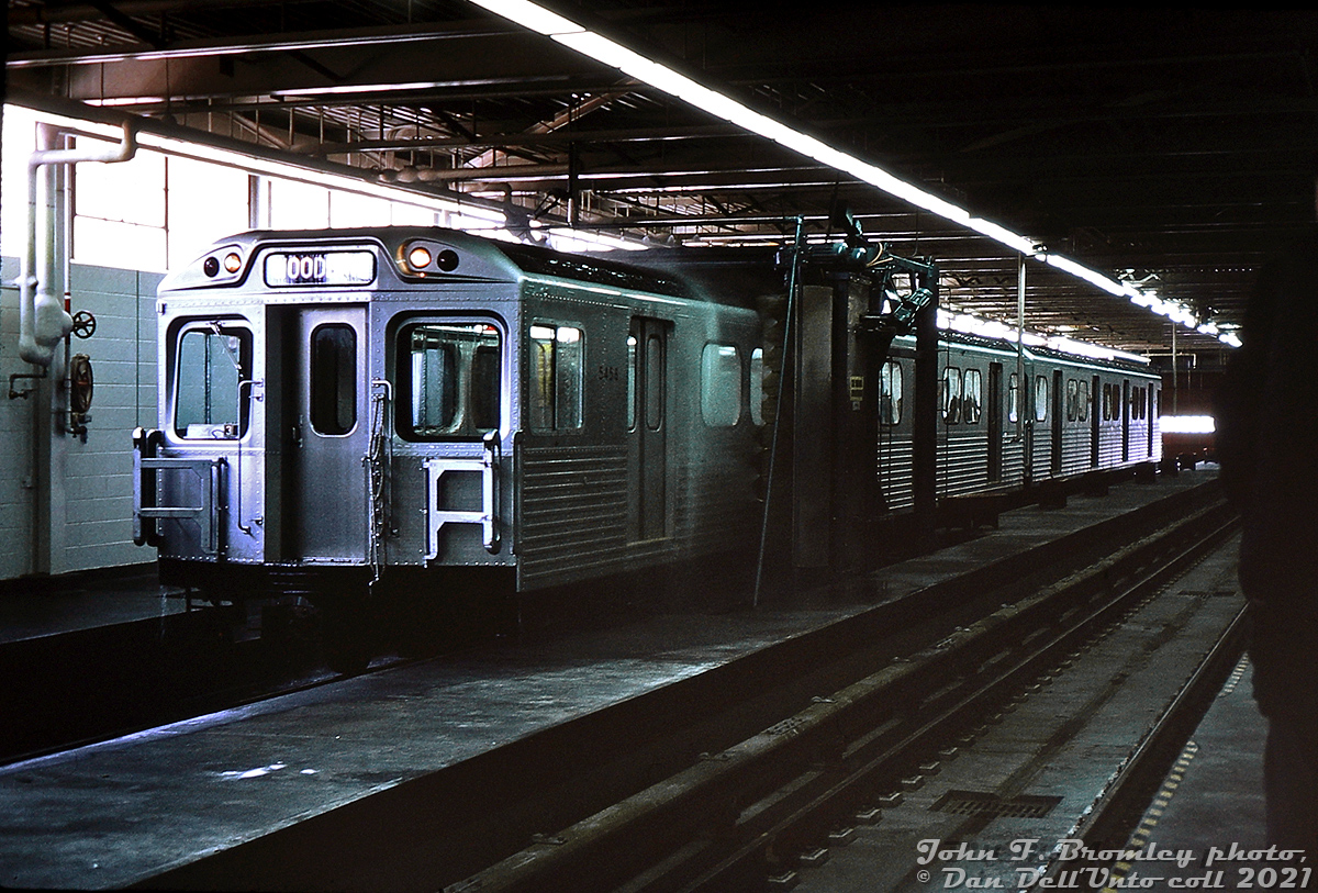 Brand new TTC H1 subway cars 5458 and 5459 make a demonstration run through the wash rack at Greenwood Yard car shops, during a tour of the new Greenwood Yard, shops and subway line a few days before official opening day on February 26th 1966. Interior wash racks were installed in the car shop building at Greenwood where cars are cleaned and inspected before service, in order to allow washing cars' exteriors during the winter to prevent things from freezing up. Warm air jets dry the car off after going through the wash rack, and interiors were cleaned by shop forces at the same time.

For the film enthusiasts, this was noted by John on the slide as shot at f4.0 at 1/50 of a second, on ASA 25 (!) Kodachrome slide film, underexposed by one stop, so the entire image was really, really dark. Even the scanner settings and some editing couldn't make any of the scans sufficiently bright, so the slide was illuminated by a bright light source and shot with a DSLR zoomed in very close, and edited from there.

John F. Bromley photo, Dan Dell'Unto collection slide.

More Greenwood: overhaul & repair shop: http://www.railpictures.ca/?attachment_id=32686
New subway car being unloaded: http://www.railpictures.ca/?attachment_id=32686