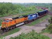 A nice splash of colour on an overcast day. NS train 328 with a borrowed BNSF Dash-9 and a former Conrail SD40 head along the "cow path" on there way to Buffalo with a couple loaded frame flats and a long train of empty auto boxcars. The traffic on this train has changed a lot over the years and by the end it was mainly auto parts destined for the now demolished Ford plant in Talbotville, near St. Thomas.