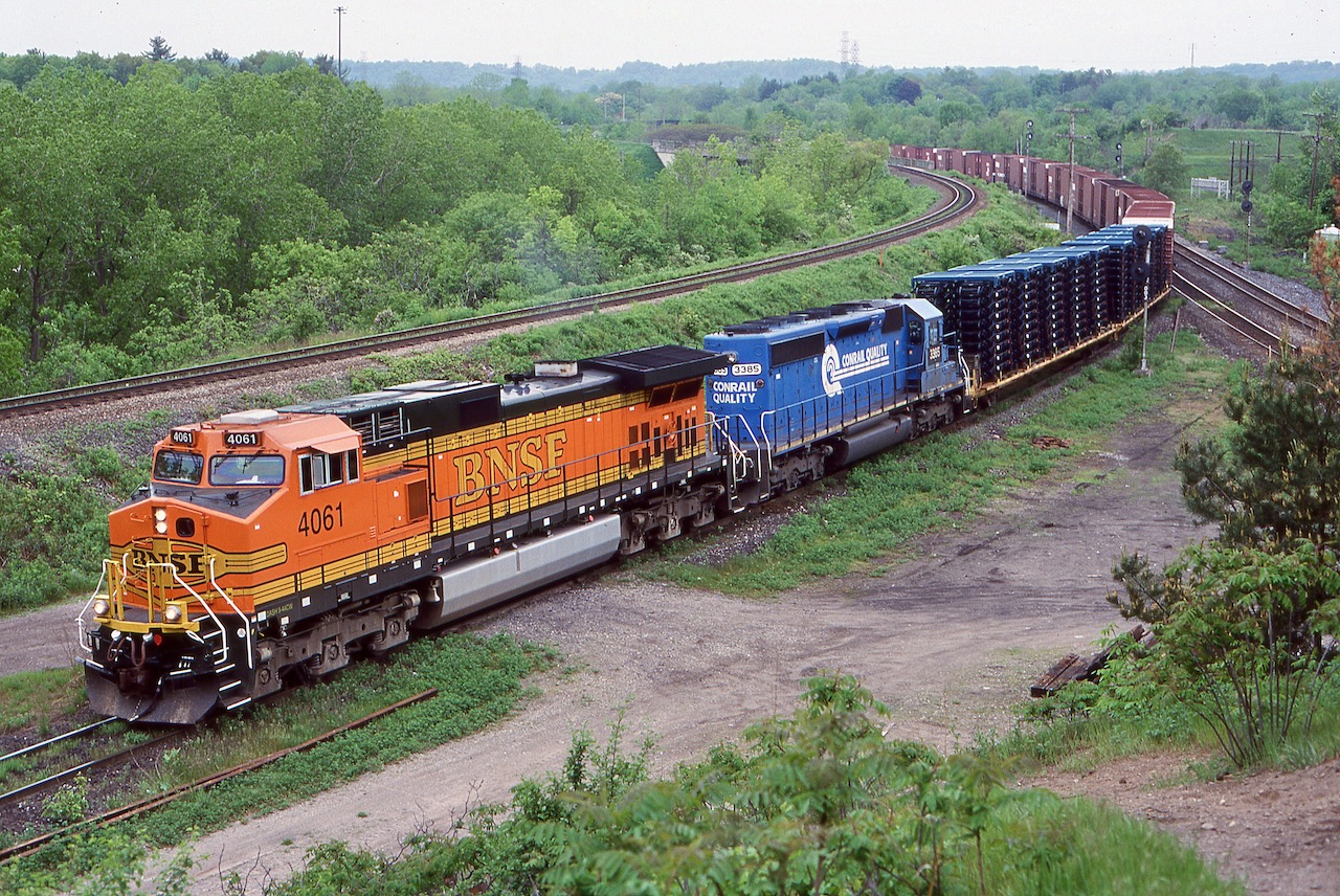 A nice splash of colour on an overcast day. NS train 328 with a borrowed BNSF Dash-9 and a former Conrail SD40 head along the "cow path" on there way to Buffalo with a couple loaded frame flats and a long train of empty auto boxcars. The traffic on this train has changed a lot over the years and by the end it was mainly auto parts destined for the now demolished Ford plant in Talbotville, near St. Thomas.