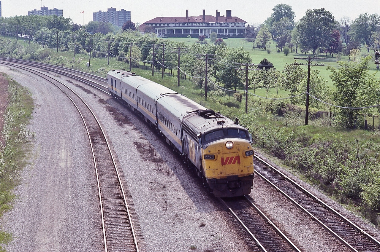 The 1914 built clubhouse for the Scarboro Golf and Country Club provides a classic background for the afternoon Bonaventure,


  VIA train 56, powered by GMD 1957 built  FP9A #6523,  is braking for the Guildwood station stop. 


   At the Kingston Road overpass, June 5, 1983 Kodachrome by S.Danko


  interesting:


   commencing at the 1913 course opening: “A friendly GTR conductor would allow golfers 'a free drop' at the pathway near the (SG&CC )clubhouse....this tradition continued for many years....” [ per Scarborough Centennial Book page 10 ]


   sdfourty