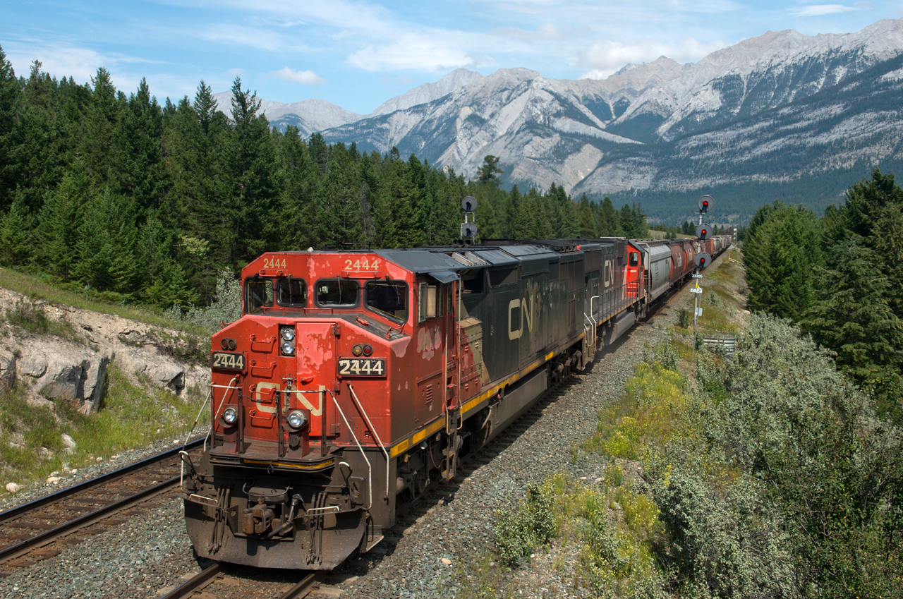 After having to stop at English to let a couple eastbound by, a set of westbound grain loads with CN 2444 and IC 1037 up front are nearly at the crew change point of Jasper.