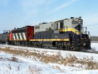 836 heading to the Cold Lake air force base with a solid train of jet fuel tanks. Taken at a farm crossing West of Radway using Konica print film. 