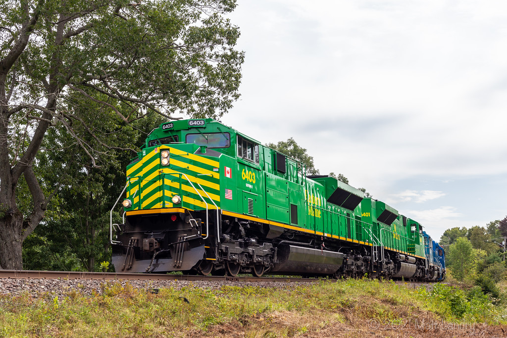 NBSR 6403 powers train 907 as they round the bend after heading through Westfield Beach, New Brunswick on an overcast Labour Day weekend.