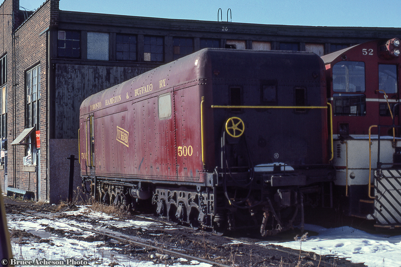 TH&B steam generator 500 is seen at Chatham Street alongside 52. Originally built by ALCO in 1929 as the tender of TH&B 4-6-4 number 502, it would be rebuilt into a steam generator unit in 1955 after the locomotive's retirement, serving in this capacity until being sold in 1986 to the Green Mountain Railroad in Vermont, and in 2002, was transferred to Steamtown, where it is preserved as New York Central X5313.