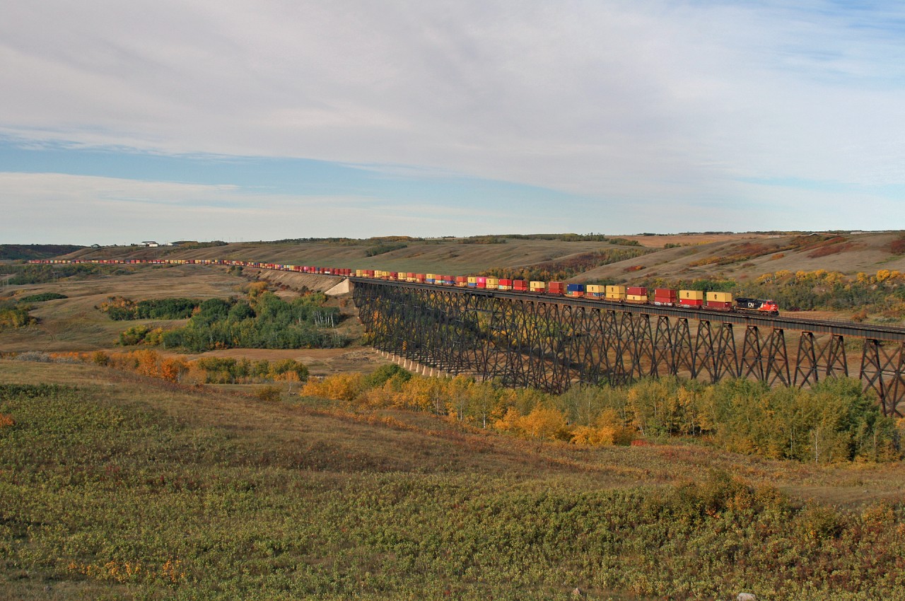 CN Q 10651 20: CN 3052, CN 8861, CN 3862 running DP 1x1x1 soars over the Battle River at Fabyan, Alberta with 163 loads for Montreal.