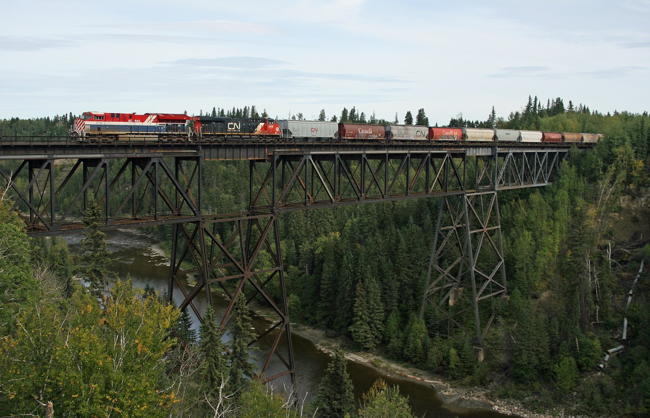 CN G 86343 13 soars over the Pembina River at Entwistle with CN 3115, CN 3849 and mid train remote CN 3267 hauling 189 grain loads to Prince Rupert.