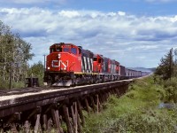 The 5580, 5503 and 5589 are going to tie into 50 loads of sulphur as soon as they clear the trestle. By the time they reach main street in Redwater (2.5 miles from here), progress will be down to less than 15mph. It will be another couple of miles until the units have the train back up to speed. Caboose 79392 was at the rear. Also, what looks to be brake smoke is dust from freshly applied and spread ballast. This photo was taken with Kodachrome 25 at 1/500th. I made no entry for aperture, which must have been close to wide open (50mm, f/1.4). Imagine being track side using iso25, could present challenges.