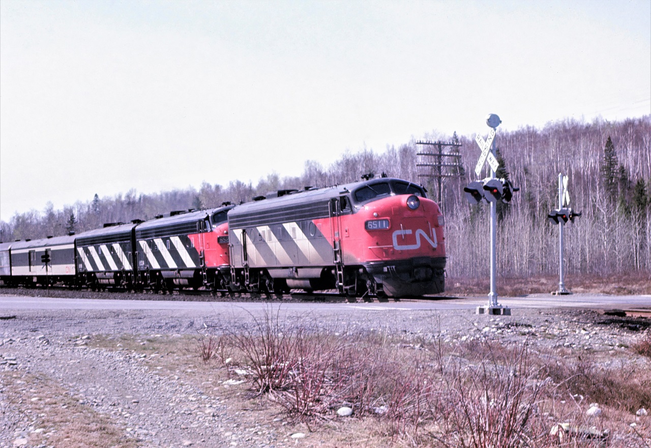 The Panorama, CN train 105 with 6511 6524 6616 for power slows to enter the passing track at Milnet, Ontario for a meet with train 2 the Super Continental.  The lead unit 6511 was added at Capreol.  It had arrived the previous night on 106 which explains the dirt on the unit compared to the other two units which were freshly washed in Montreal prior to heading west. The combined Toronto and Montreal sections required a third unit west of Capreol.