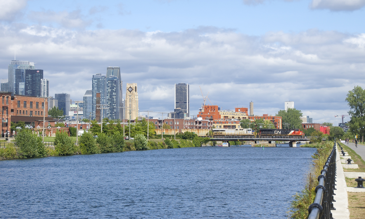 ES44AC's in two paint schemes are on the head end (CN 3874 & ex-CREX CN 3935) as potash train CN B730 crosses the Lachine Canal.
