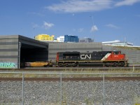 CN 599 with CN 8918 and baretables for the Port of Montreal slowly emerges from the Turcot Interchange. In a short distance it will stop and have to wait for numerous train to pass before it can continue towards the port.