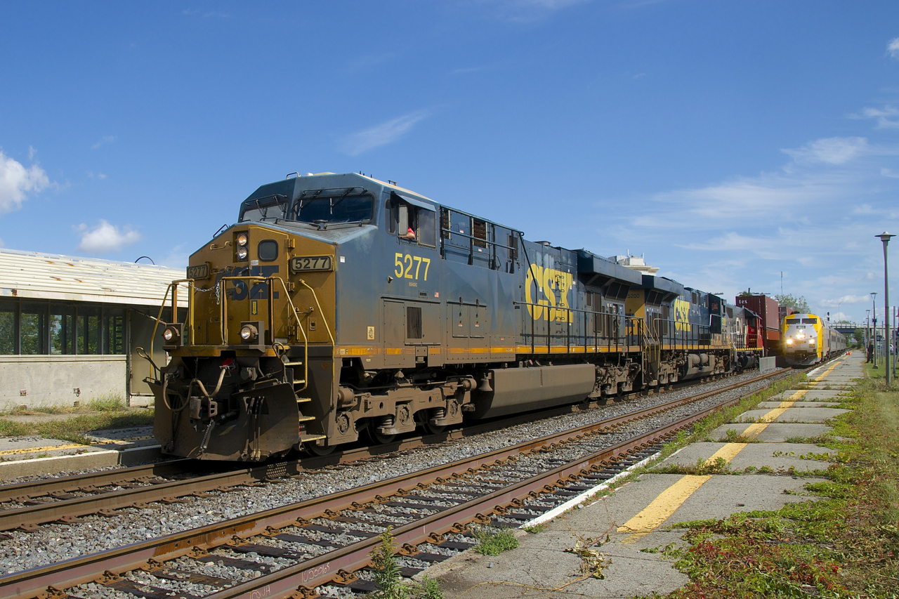 A short CN 327 with CSXT 5277, CSXT 5277 and CN 4721 for power temporarily passes a stopped VIA 35 at Dorval Station. CN 327 will have to stop just further ahead to let VIA 35 and CN 149 pass before it departs.