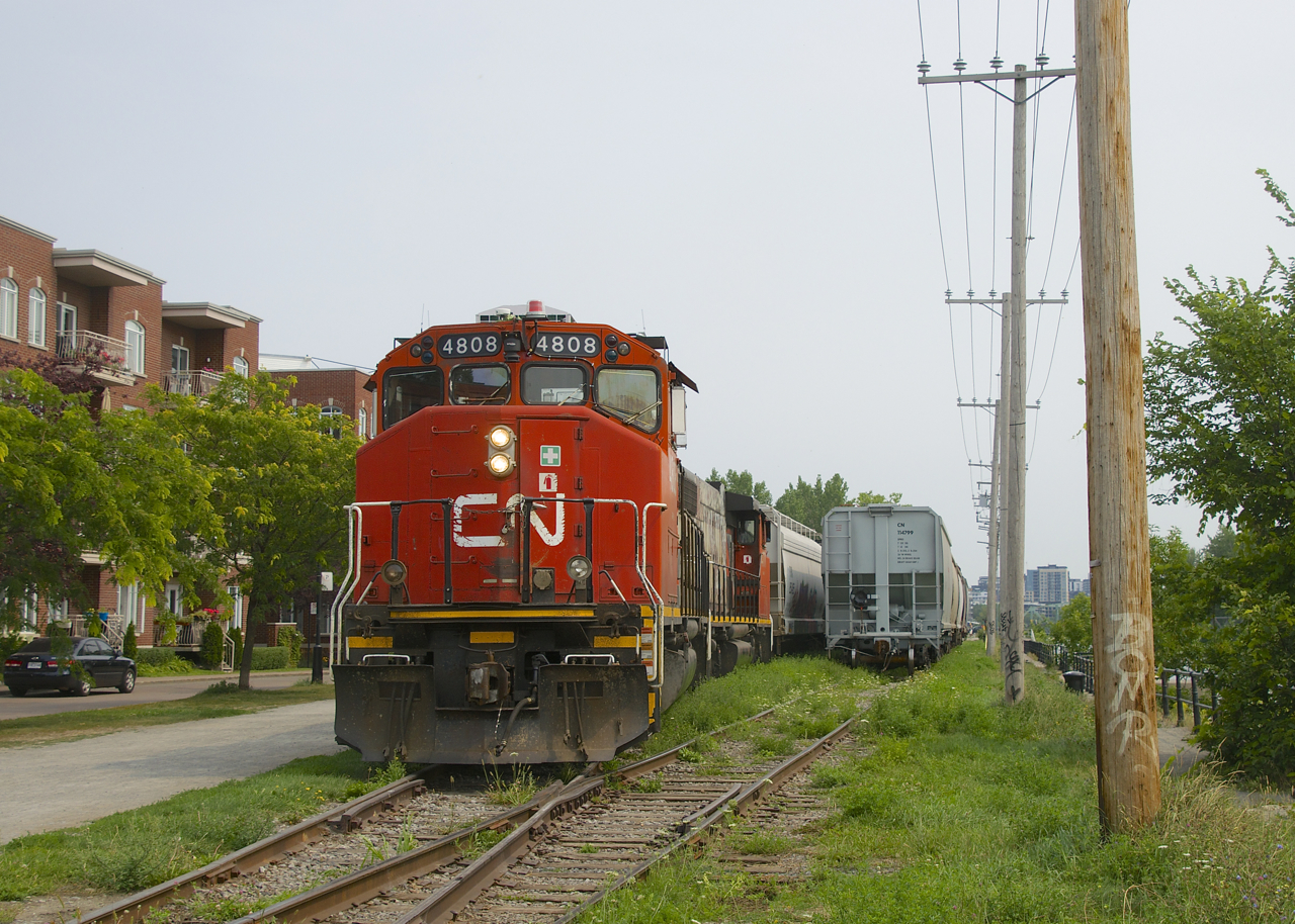 After picking up grain empties at Ardent Mills and leaving them in the siding at left, the Pointe St-Charles Switcher with CN 4808 & CN 4771 for power is about to couple onto the loads (at right) and shove them towards the mill.