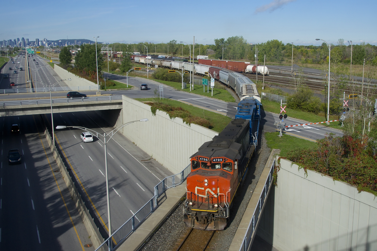 CN 522 is leaving Southwark Yard and taking the Rouses Point Sub to reach St-Jean-sur-Richelieu as it crosses Route 116 with CN 4795, GMTX 2257 and 13 cars.
