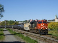 Looking like a unit oil train, CN X306 has a buffer car and crude oil cars behind it (with mixed freight further back) as it rounds a curve with CN 3839 up front and CN 3920 mid-train with extra tonnage for Joffre Yard, where this train would terminate. 