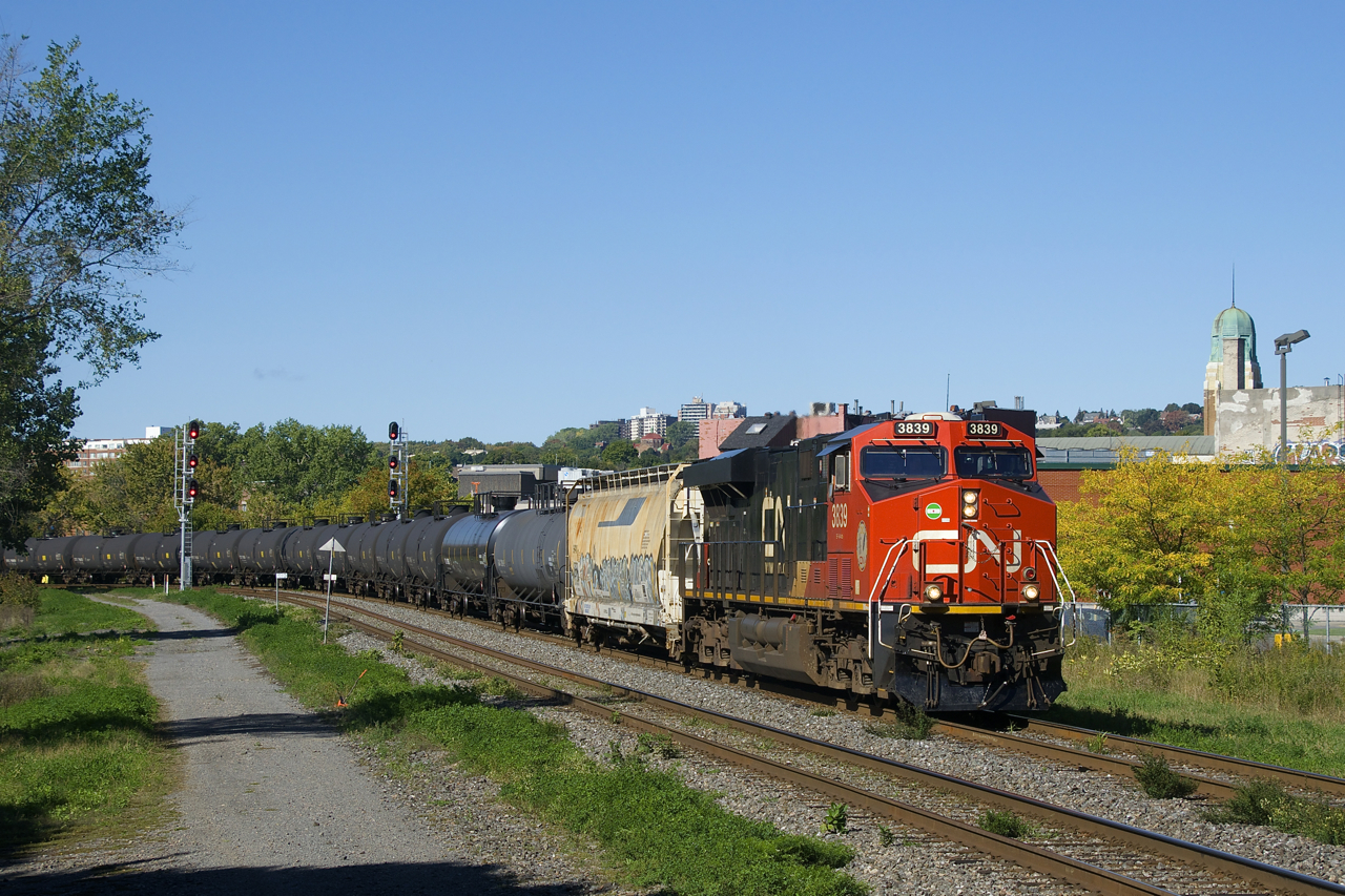 Looking like a unit oil train, CN X306 has a buffer car and crude oil cars behind it (with mixed freight further back) as it rounds a curve with CN 3839 up front and CN 3920 mid-train with extra tonnage for Joffre Yard, where this train would terminate.