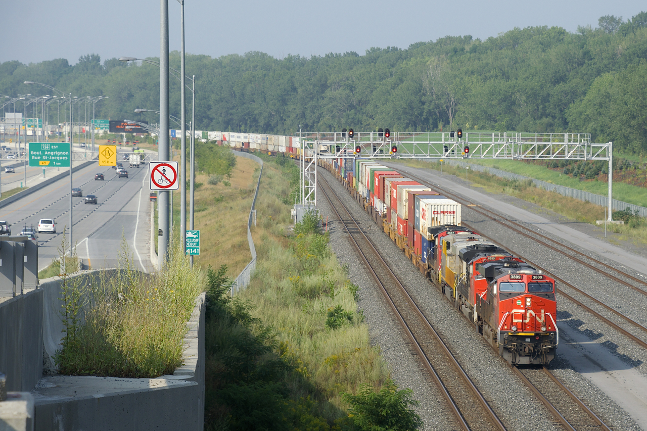 CN 120 has four units up front (CN 3809, CN 8890, CN 3932 & CN 2687) as it heads east past a large signal gantry on a portion of CN's Montreal Sub that is only a few years old.
