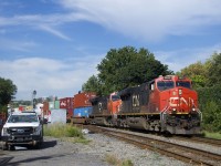 CN 120 passes some foremen as it prepares to cross the St-Ambroise Street level crossing.