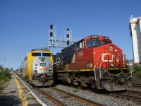 CN 322 passes the tail end of a combined VIA 33/633 which is making its stop at Dorval Station. CN 322 is one of many eastbounds on the morning after the Kingston Sub was reopened after a collision at Prescott closed it for about 36 hours.