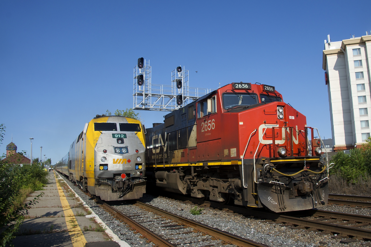 CN 322 passes the tail end of a combined VIA 33/633 which is making its stop at Dorval Station. CN 322 is one of many eastbounds on the morning after the Kingston Sub was reopened after a collision at Prescott closed it for about 36 hours.