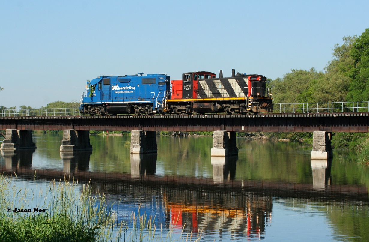 The early Sunday morning calm is briefly interrupted as CN L542 slowly rubbles across the Speed River bridge in the village of Hespeler on the Fergus Spur. CN 1408 and GMTX 2279 were returning to Guelph light-power after setting-off loaded bulkhead cars at Hunts Logistics near Eagle Street as well as Gillies Lumber at Industrial Road in Cambridge.