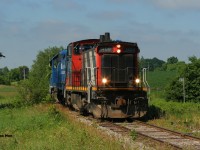 Amongst the summer growth and green foliage CN L542 slowly passes Mile 27 on the Fergus Spur. CN 1408 and GMTX 2279 were returning to Guelph light-power after setting-off loaded bulkhead cars at Hunts Logistics near Eagle Street as well as Gillies Lumber at Industrial Road in Cambridge.