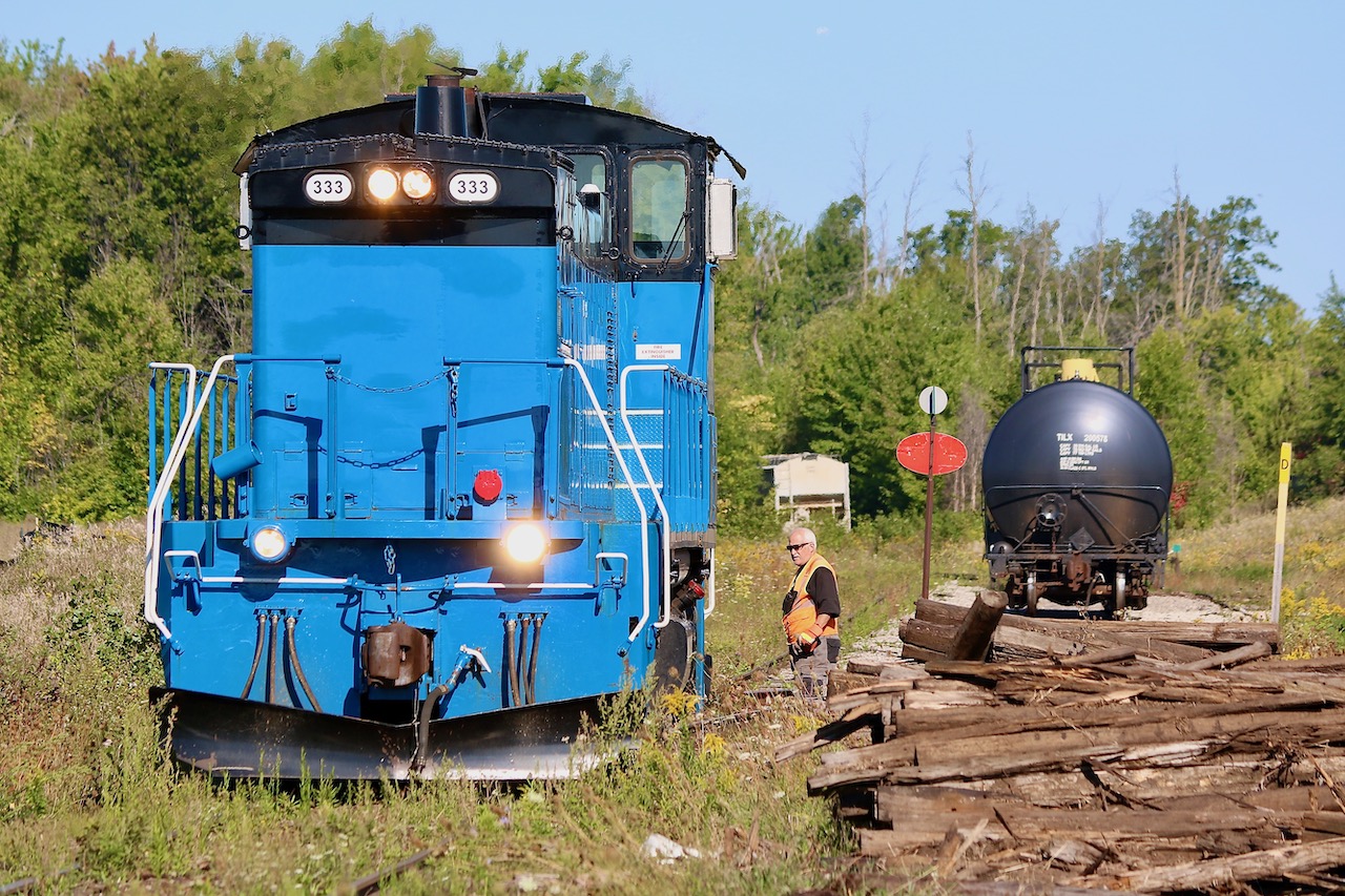 Back in the CP days Snelgrove was the location of a trans-loading facility, with the siding often full of covered hoppers. Once CP rid itself of the Owen Sound sub. the facility was left empty and all translating was moved to Streetsville. The siding did however remain and during the Cando years it was often used as not only a run around location for trains serving the one remaining customer about a mile to the south, but it also served as a turn around spot for the popular Credit Valley Explorer excursion trains. When Cando terminated its contract on the line the passenger trains also ended for good sadly. Today as trillium rolls through its last year of operating the line, the siding is still used regularly for running around tank cars destined for the last customer on Brampton, and typically tank cars destined for that customer will be left in the siding here rather then dragged up to Orangeville and back again on the next trip. The customer is best worked on the southbound trip rather than the northbound trip as the switch faces south. I was a bit confused this day as on arrival the power was on the north end of the tank cars even though the train was still in the process of heading south to Streetsville, but it appeared that the tank cars needed to be rotated before dropping one at the customer. The brakeman has taken to the ground to lift the derail and line the switch. The rest of the train can be seen in the distance. The pile of rotten ties are from some track maintenance done after Trillium took over the line. It appears though that no more maintenance will be done with the end of operations quickly approaching, and now the weeds are already taking over. A sad ending for a one time busy branchline.