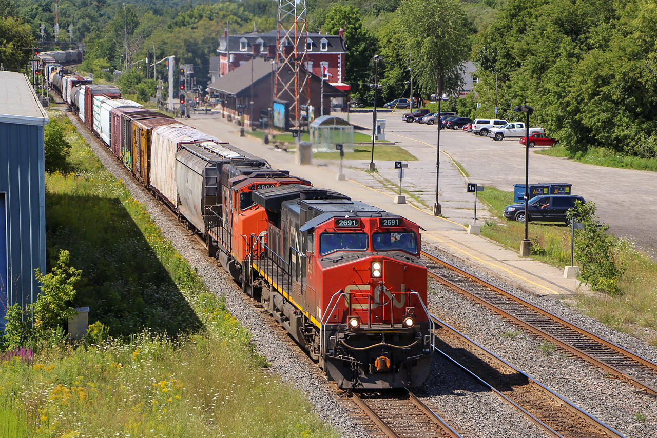 CN Dash 9-44CW 2691 and GP38-2(W) 4809 lead an eastbound through Brockville on August 9, 2015. ES44DC 2277 was the mid-train DPU.