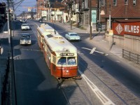 The same photographer who shot <a href=http://www.railpictures.ca/?attachment_id=38483><b>this photo</b></a> of CP 7026 crossing the former TG&B "Old Bruce" service track over Bloor Street, was also shooting streetcars that day in the same spot. They caught this pair of TTC PCC's lead by 4494 MU'ed with a 4600-series A11 car in Queen service, heading westbound on Bloor Street past Perth Avenue about to duck under the "subway" (common Toronto parlance for an underpass or viaduct before transit subways started being built) under the service track, the CN Weston Sub, and CP Galt Sub mainlines. After ducking under the rail corridor and climbing the grade to Dundas, the cars would continue west for Jane Loop. The local Milnes coal & fuel oil dealer is visible at the southwest corner of Bloor & Perth. The signage on the building opposite reads "H. Waines Custom Cabinet Work and Upholstering, 1435 Bloor W, LE-5-2638"<br><br>PCC cars serving the busy Bloor and Danforth streetcar lines were often <a href=http://www.railpictures.ca/?attachment_id=38513><b>MU'ed together</b></a> to handle the larger passenger loads, and certain classes of cars were equipped with front and rear couplers for such operations. Once the crosstown Bloor-Danforth subway line opened between Keele and Woodbine in February 1966, streetcar operations ended on that stretch of Bloor, and the Bloor and Danforth <a href=http://www.railpictures.ca/?attachment_id=31201><b>"shuttle" runs</b></a> at both ends that ran until the extensions to Islington and Warden opened in May 1968 were able to get by with single cars. MU'ed PCC operation continued on busier routes such as Queen however.<br><br><i>Original photographer unknown (but visible at bottom right!), Dan Dell'Unto collection slide.</i>