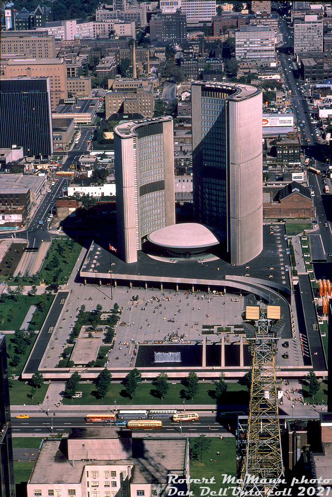 September 1st 1921 to September 1st 2021 marks 100 years of the TTC serving the City of Toronto! Here we have a fine photo by Robert McMann taken in September 1967 showing part of the downtown Toronto core, with the then-"new" City Hall (opened 1963) and Nathan Phillips Square in the middle. Along the bottom of the image is Queen Street, with TTC PCC 4695 heading eastbound on the Queen route. Westbound, a TTC GM New Look (or "fishbowl") bus passes two coaches parked on the north side, followed by one of the TTC's 1950-series of Can-Car buses equipped with sight-seer windows cut into the roof. Across the middle of the image is Dundas Street, and to the left one can see a PCC between buildings heading east on Dundas at Elizabeth. On the far right, another PCC turns from northbound Bay to westbound Dundas, likely having come from City Hall Loop (Louisa-James-Albert-Bay) on the Dundas route. Two more GM fishbowls wait northbound and southbound on the 6 Bay route. Across the top of the image is College Street, and Queen's Park is just visible in the upper left, decked out in blue for Canada's Centennial 1867-1967 celebrations.

Robert D. McMann photo, Dan Dell'Unto collection slide.