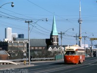 TTC PCC 4729 (an A13-class car originally built new by Pullman in 1947 for Birmingham, Alabama) ambles westbound on Dundas Street West on the Carlton route bound for High Park Loop, seen here at Sterling Road after crossing the CN Newmarket Sub overpass.<br><br>Markers of Toronto's downtown core are visible in the distance: BMO's First Canadian Place, the TD Centre towers, and most notably the brand-new CN Tower, that would officially open to the public in June. The church in the background is St. Helen's Parish (originally built in 1909) in the Little Portugal area at Dundas & St. Clarens.<br><br><i>Robert D. McMann photo, Dan Dell'Unto collection slide.</i>