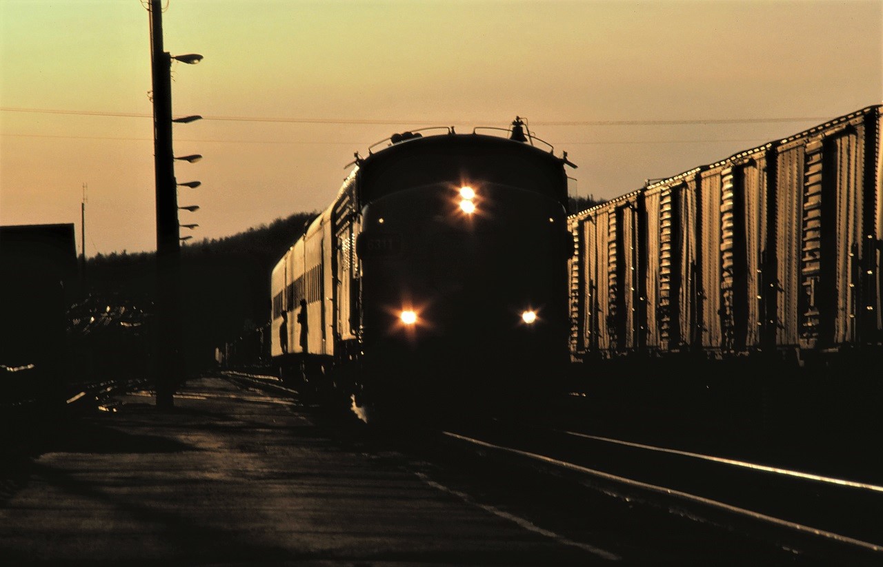 VIA train 676 arrives in Capreol, Ontario at sunset on April 17, 1987.  With classification lights displaying white, the train is operating as an extra.  It appears that either the crew or passengers or both can't wait to get off the train.